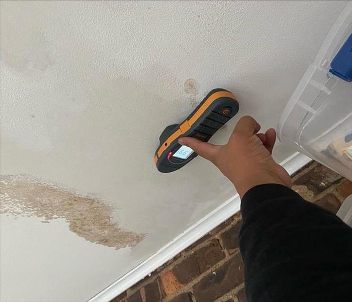 SERVPRO technician uses moisture sensor on damaged drywall