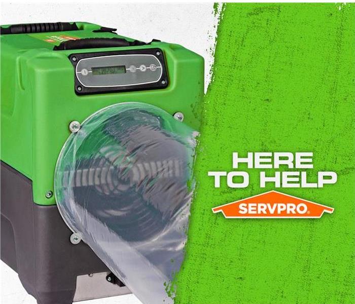 Green SERVPRO air mover with the caption “Here to Help”